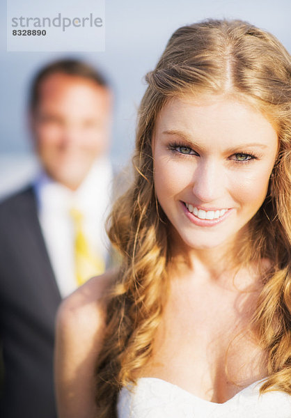 Portrait of smiling bride  groom in background
