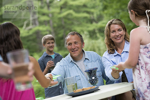 Biologische Landwirtschaft. Eine Familienfeier im Freien mit Picknick. Erwachsene und Kinder.