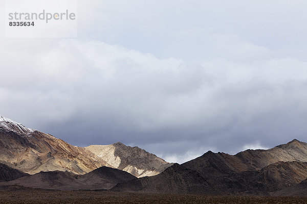 Schneebedeckte Berge und ein unheilvoller Himmel  in den Panamint Mountains  im Death Valley National Park.