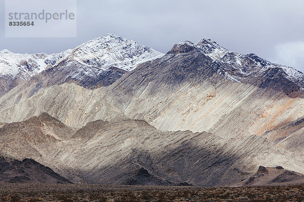 Schneebedeckte Berge und ein unheilvoller Himmel  in den Panamint Mountains  im Death Valley National Park.