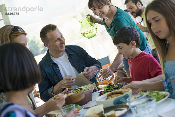 Eine Familienfeier um einen Tisch in einem Cafe. Erwachsene und Kinder.