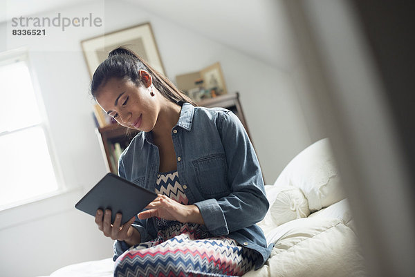 Eine junge Frau benutzt ein digitales Tablett.