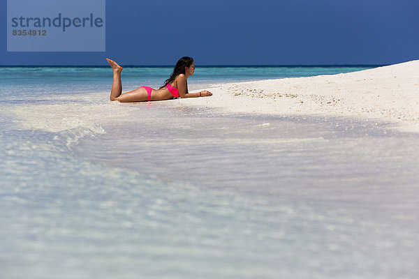 Frau im pinken Bikini liegt am Strand  Malé  Nord-Malé-Atoll  Malediven