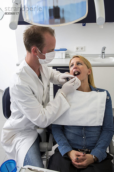 Frau beim Zahnarzt  Zahnarzt kontrolliert die Zähne  Deutschland