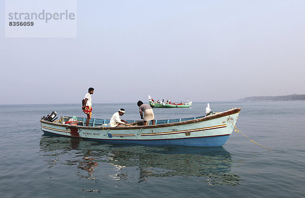 Einheimische Muschelfischer in ihrem Boot vor der Küste  Varkala  Kerala  Indien