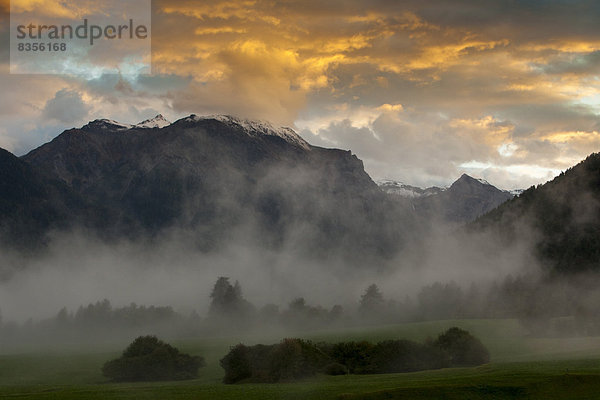 Abendstimmung mit aufsteigendem Nebel im Herbst im Val Müstair  Provinz Südtirol  Trentino-Südtirol  Italien