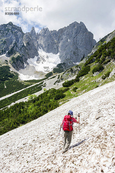 Wanderin überquert ein Schneefeld  auf dem Wilder-Kaiser-Steig  Kaisergebirge  bei Ellmau  Tirol  Österreich