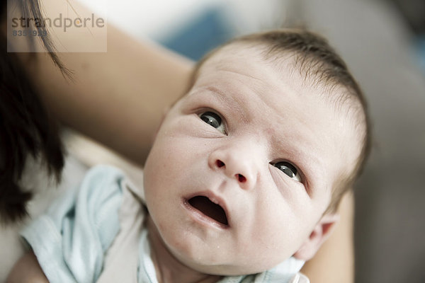 Porträt eines männlichen Neugeborenen in den Armen seiner Mutter