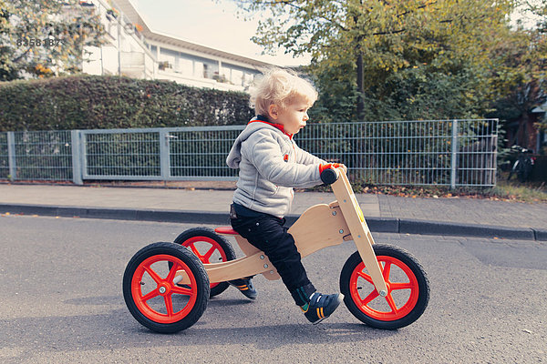 Little boy with wood tricycle