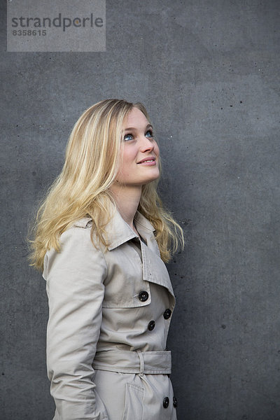 Blond woman in front of a wall