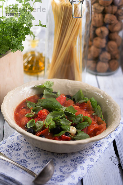 Sauce made of grilled tomatoes with black olives and leaves of basil  studio shot