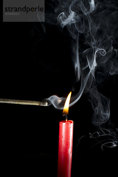 Burning candle with matchstick