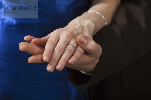 Hände von Mann und Frau mit Verlobungsring