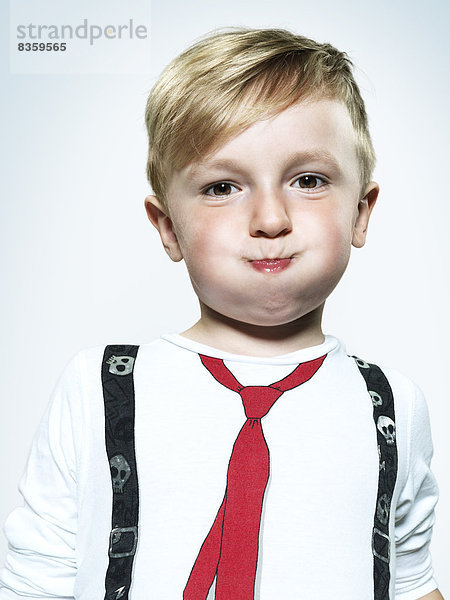 Portrait of little boy blowing his cheeks  studio shot