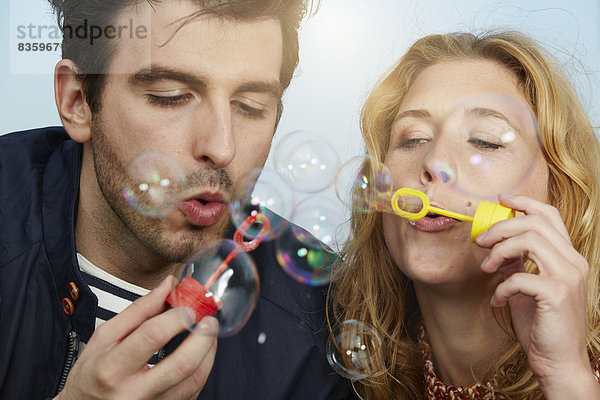 Germany  Dusseldorf  Young couple making soap bubbles
