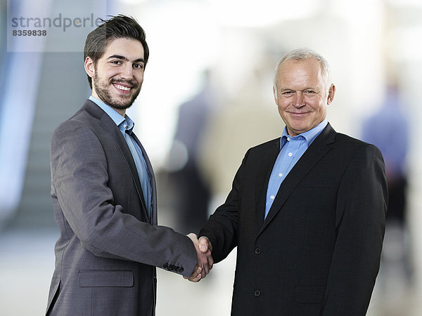 Porträt zweier Geschäftsleute beim Händeschütteln