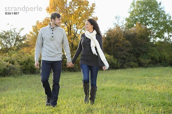 Lächelndes Paar geht im Herbst spazieren