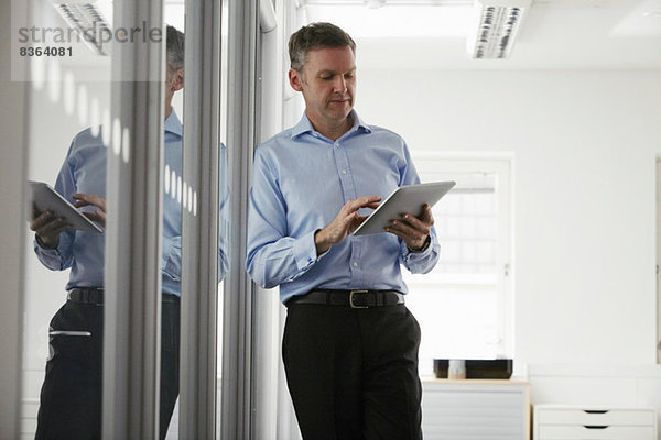 Mann mit digitalem Tablett im Büro