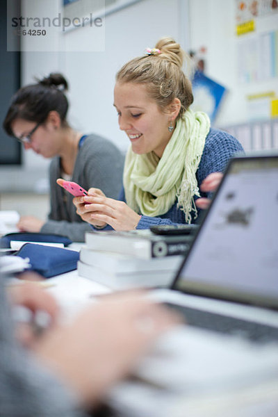 Frau mit Smartphone im Klassenzimmer