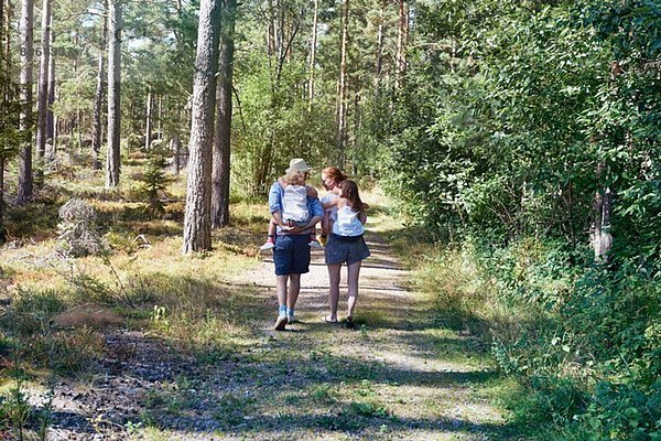 Eltern geben Töchtern Huckepack durch den Wald zurück
