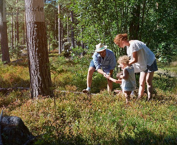 Eltern und Töchter auf Entdeckungsreise im Wald