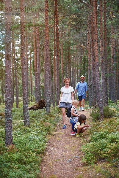 Eltern wandern mit Töchtern durch den Wald