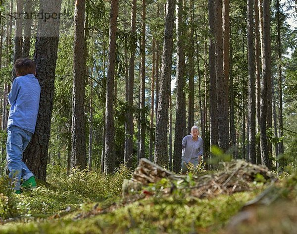 Mutter und Sohn beim Verstecken im Wald