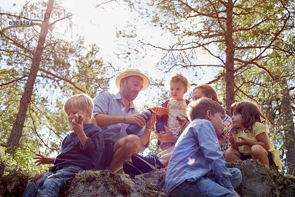 Familie mit Picknick auf Steinen