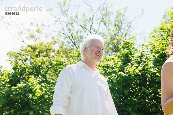 Älterer Mann in weißem Hemd  lachend