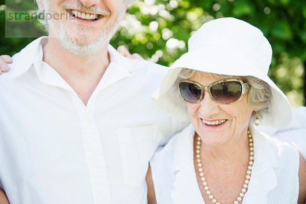 Porträt einer älteren Frau mit Sonnenbrille und weißem Sonnenhut