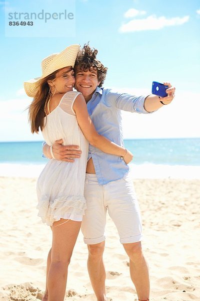 Paar Selbstfotografie mit Handy am Strand