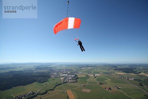 Fallschirmspringer mit Fallschirm über Leutkirch  Bayern  Deutschland