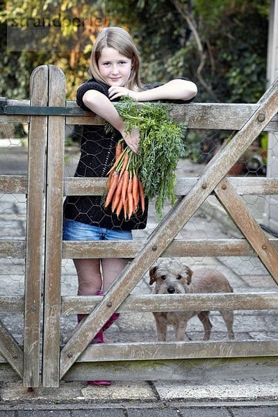 Mädchen im Garten mit Karottenstrauß