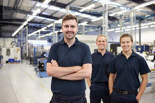 Porträt von drei Arbeitern in der Maschinenfabrik