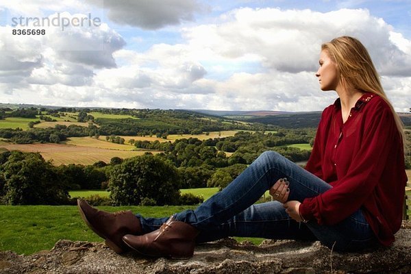 Porträt einer jungen Frau mit Blick über die ländliche Landschaft