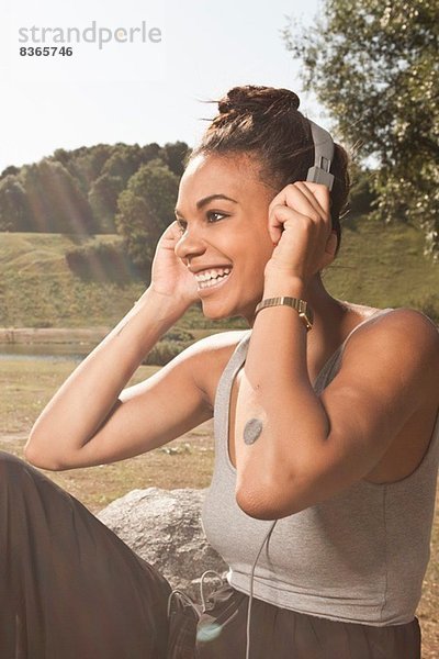 Junge Frau hört Musik im Park