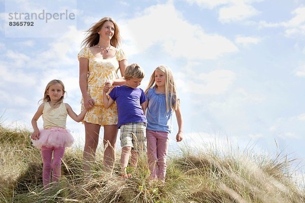 Mutter mit drei Kindern auf Dünen  Wales  UK