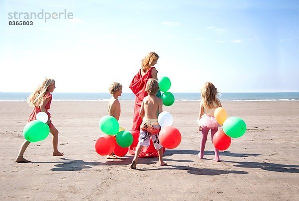 Mutter mit vier Kindern am Strand mit Ballons  Wales  UK