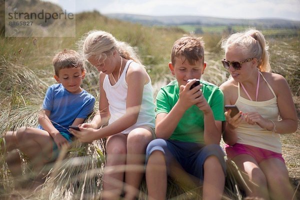 Vier Freunde beim Entspannen in den Dünen  Wales  UK