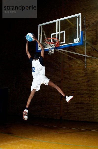 Basketballspieler beim Springen mit Ball