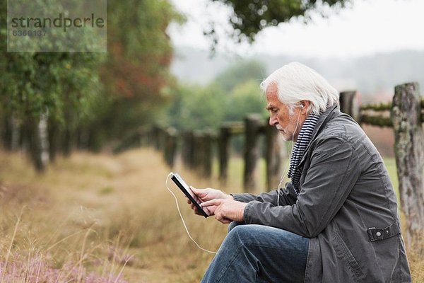 Älterer Mann mit digitaler Tablette