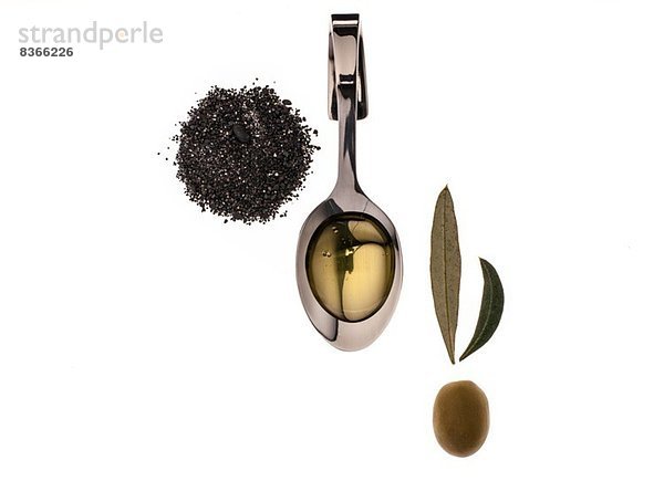 Studioaufnahme mit Oliven  Blättern  Pfeffer und Olivenöl auf dem Löffel