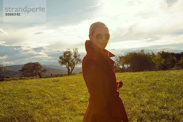 Junge Frau im Feld posiert in Sonnenbrille