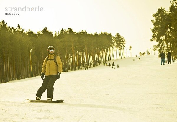 Junger Mann beim Snowboarden auf dem Berg