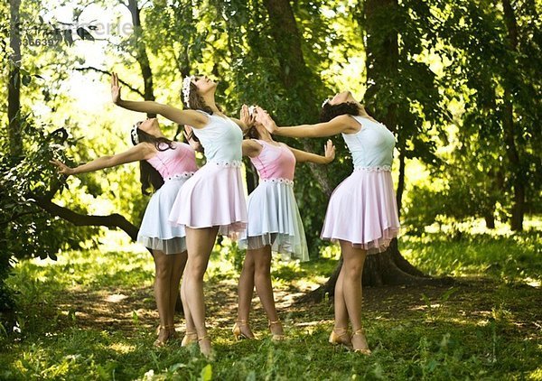 Vier junge Balletttänzerinnen spielen im Wald