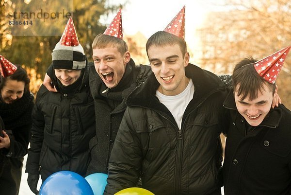 Gruppe junger Freunde mit Partyhüten