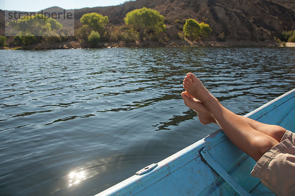 Junge entspannt mit den Füßen auf dem Boot
