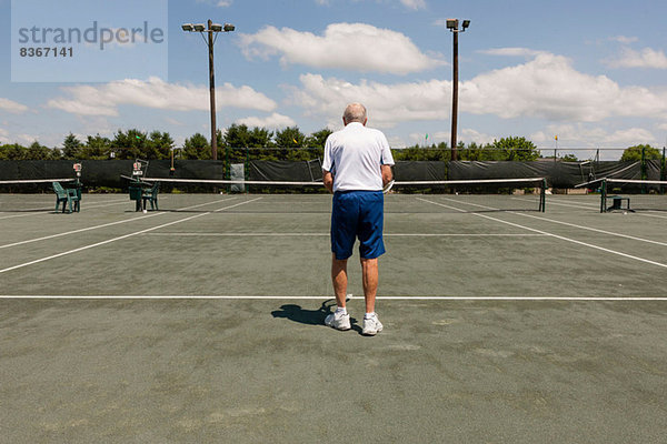 Rückansicht des Senioren auf dem Tennisplatz