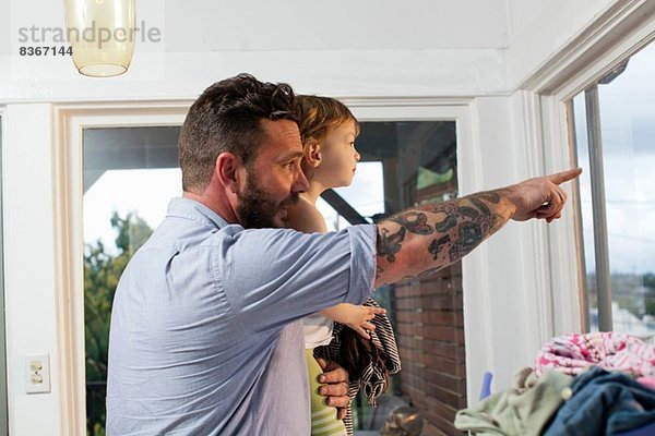 Vater und Tochter schauen durchs Fenster