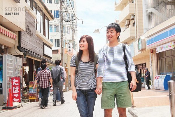 Junges Paar hält sich an den Händen und geht durch Kamakura  Japan